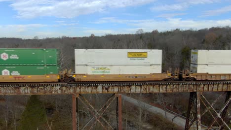 Aerial-Side-Shot-of-an-Intermodal-Freight-Train-Crossing-the-Pope-Lick-Trestle-in-Louisville,-Kentucky-during-the-Winter