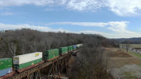 Aerial-Shot-Pulling-Back-from-an-Intermodal-Train-Crossing-the-Pope-Lick-Trestle-in-Louisville,-Kentucky-on-a-Sunny-Winter-Day