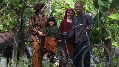 Javanese-family-with-their-two-children-on-an-ancient-bicycle,-Central-Java,-Indonesia