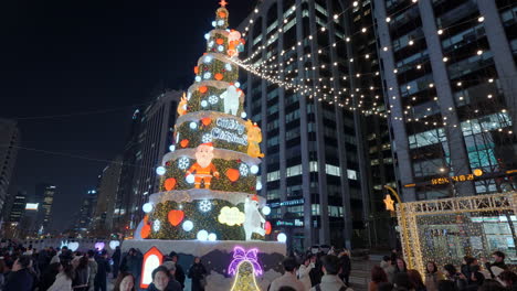 Nachtansicht-Des-Weihnachtsbaums-Und-Der-Menschenmenge,-Die-Auf-Dem-Cheonggyecheon-Flussplatz-Spazieren-Geht