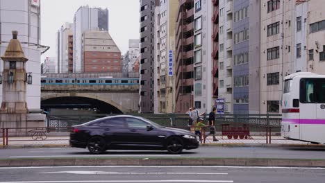Slow-motion-panning-shot-of-Akihabara-Streets-in-Japan,-Slow-Motion-View-as-Train-Passes-Canal,-Japan