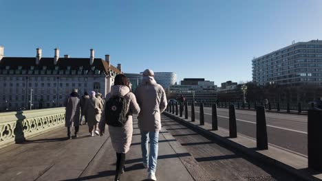 POV-Walking-Behind-Tourist-Couple-Walking-Over-Westminster-Bridge-On-January-Winter-Day