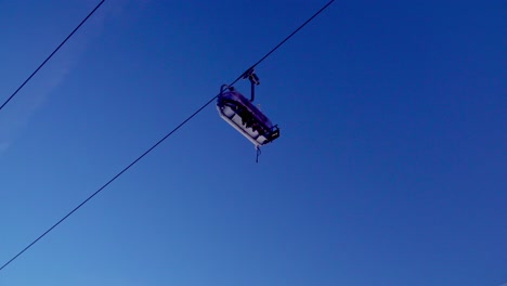 Two-people-ride-a-chairlift-in-a-ski-resort-in-the-South-Tyrolean-alps-in-Italy