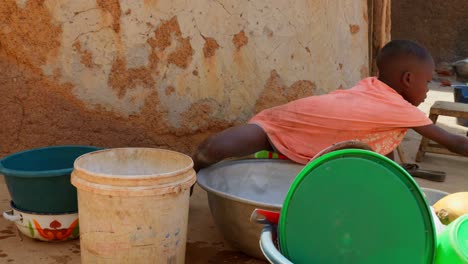 young-child-children-black-kid-of-Africa-washing-dishes-in-remote-rural-village-close-up