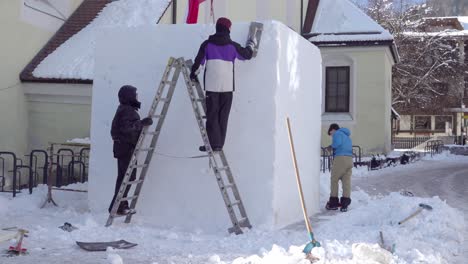 Austrian-HTL-students-work-on-their-snow-sculpture,-Synergy,-during-the-33rd-Dolomites-Snow-Festival-in-Innichen---San-Candido,-South-Tyrol,-Italy