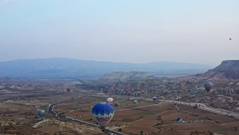 Mehrere-Heißluftballons-Fliegen-über-Kappadokiens-Wüstenland-In-Der-Zentraltürkei