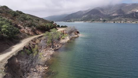 water-edge-of-bouquet-reservoir-santa-clarita-california-AERIAL-TRUCKING-PAN-60fps