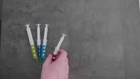 several-syringes-filled-with-colorful-liquid-symbolizing-social-media-addiction-with-the-youtube-symbol-being-picked-up