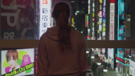 Un-Turista-En-Tokio-Parado-Frente-Al-Distrito-De-Vida-Nocturna-De-Shinjuku,-Tokio,-Japón