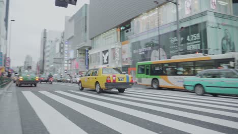 a-yellow-cab-driving-over-a-street-in-Tokyo,-Japan