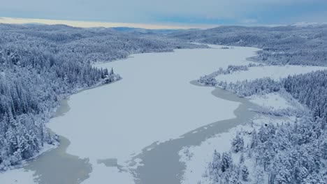 Vista-Aérea-Del-Lago-Congelado-Y-Los-Bosques-En-Indre-Fosen,-Noruega-Durante-El-Invierno---Disparo-De-Drones