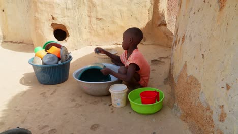 Schwarzes-Afrikanisches-Kleines-Kind,-Kind,-Das-Geschirr-In-Einem-Abgelegenen-Ländlichen-Dorf-Afrikas-Spült,-Armutskonzept