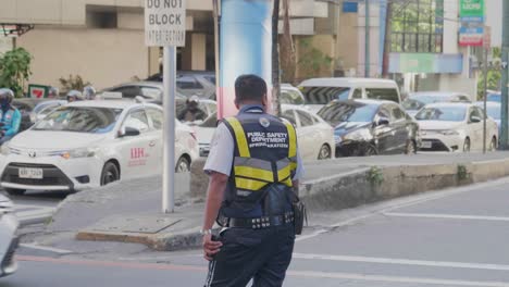 a-policeman-regulates-traffic-at-an-intersection-in-Manila,-Philippines