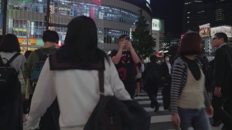 Asian-people-walking-over-a-crowded-street-in-Tokyo,-Japan-at-night