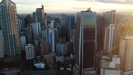 Aerial-view-in-front-of-modern-buildings-in-Metro-Manila,-Philippines,-golden-hour