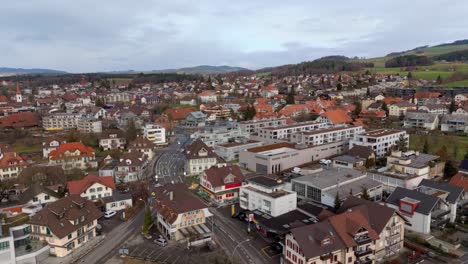 Swiss-town-with-buildings-and-roads,-overcast-sky,-aerial-view