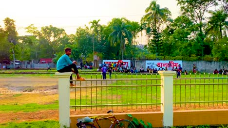 View-of-a-local-sports-field-with-a-crowd-and-tropical-trees-in-the-background---local-cricket-tournament