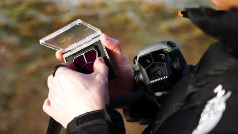 Over-shoulder-shot-of-person-hold-drone-and-open-neutral-density-filter-case