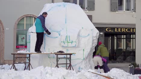 British-artists-work-on-their-snow-sculpture,-Plug-in-Intelligence,-during-the-33rd-Dolomites-Snow-Festival-in-Innichen---San-Candido,-South-Tyrol,-Italy