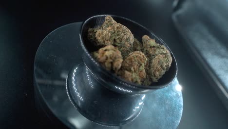 Grayish-Green-Dried-Marijuana-Buds---Close-Up-concept-Shot,-pile-of-dried-marijuana-plants-in-a-shiny-bowl,-trichomes-strains,-on-a-reflecting-rotating-stand,-studio-lights,-crane-rotate-slow-motion