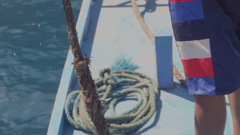 a-boatsman-pulling-an-old-anchor-rope-out-of-a-small-tourist-ship-in-the-Philippines