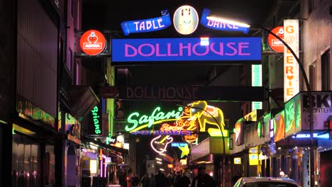 A-small-alley-at-the-Reeperbahn-in-Hamburg,-Germany-at-night-with-many-lit-up-signs
