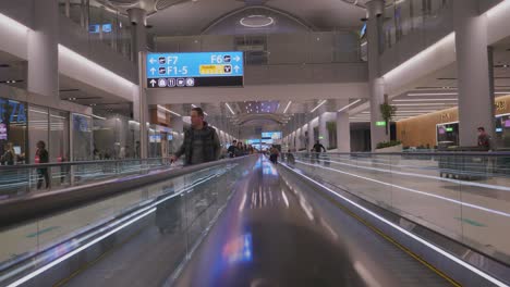 Camera-driving-through-the-Istanbul-Airport-in-Turkey-with-mayn-travellers-walking-by