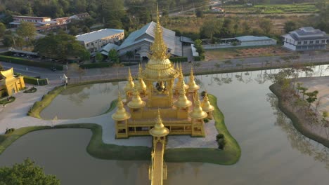 Aerial-drone-of-Wat-Rong-Khun-giant-buddhist-White-Temple-and-Golden-Temple-with-mountains-and-scenic-landscape-in-Chiang-Rai,-Thailand