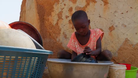 low-angle-of-african-little-black-cue-child-children-washing-dishes-in-remote-rural-village-of-Africa