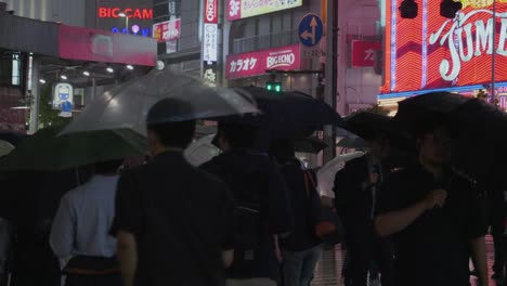 Mucha-Gente-Local-Camina-Por-Un-Tokio-Lluvioso-Por-La-Noche-Con-Muchas-Luces-De-Fondo