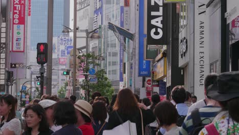 Many-pedestrians-walking-in-the-Streets-of-Shinjuku,-Tokyo,-Japan-on-an-overcast-day
