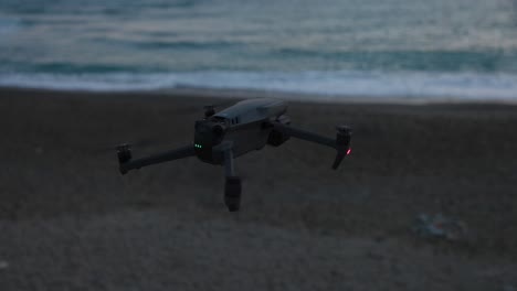 Hovering-DJi-Mavic-Pro-3-With-Green-Safety-Lights-In-Evening-At-Beach