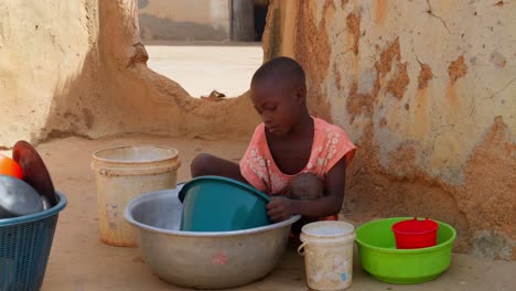 Kleine-Süße-Schwarzafrikanische-Kinder,-Die-In-Einem-Abgelegenen-Ländlichen-Dorf-Afrikas-Geschirr-Spülen
