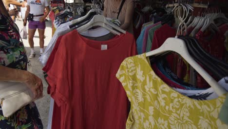 A-Woman-sorts-through-the-dresses-in-a-clothing-stall-in-the-Market-of-Cala-De-Mijas-on-the-Costa-Del-Sol