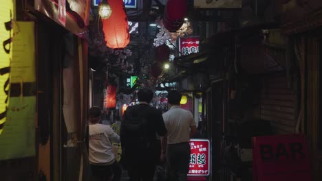 two-man-walking-down-a-narrow-street-in-tokyo,-japan