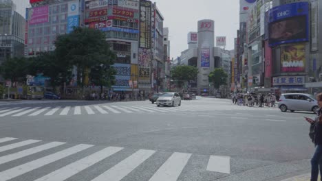 Cars-driving-over-the-world-famous-intersection-of-Shibuya-in-Tokyo,-Japan
