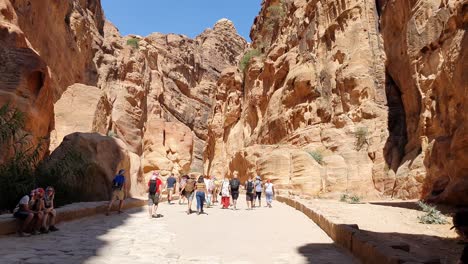 Touristen-Wandern-Zwischen-Den-Hohen-Schluchtwänden-Auf-Dem-Weg-Zur-Antiken-Stadt-Petra