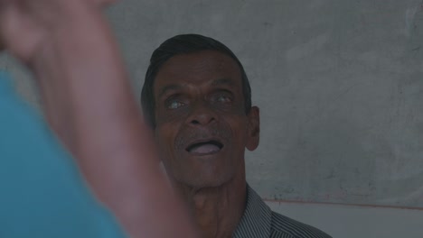 a-blind-and-disabled-old-man-looking-straight-into-the-camera-in-sri-lanka-symbolizing-the-bad-medical-supply-situation-in-developing-countries