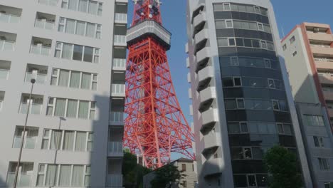 Tokyo-Tower-slowly-revealed-by-high-buildings-in-Tokyo,-Japan