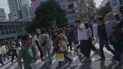 Miles-De-Personas-Caminando-Por-El-Mundialmente-Famoso-Cruce-De-Shibuya,-Que-Es-La-Intersección-Más-Transitada-Del-Mundo,-En-Un-Hermoso-Día-Soleado-En-Cámara-Lenta.