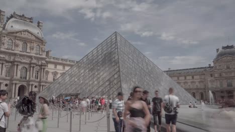 Hyperlapse-of-the-Louvre-Museum-on-a-sunny-day-in-Paris,-France-with-many-tourists-and-visitors-walking-around