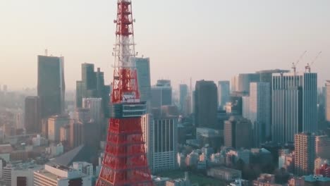 Aerial-drone-shot-of-the-famous-Tokyo-Tower-and-the-beautiful-skyline-of-Tokyo,-Japan-during-sunset