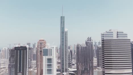 Aerial-Drone-Footage-of-the-Jumeirah-Lake-Towers-with-the-Almas-Tower-in-the-front-and-Dubai-Marina-in-the-background-on-a-very-sunny-and-bright-day