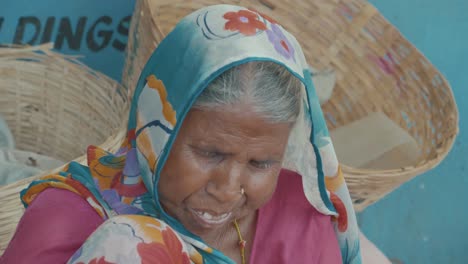 Eine-Sehr-Alte,-Aber-Komisch-Aussehende-Indische-Frau,-Die-Mit-Einem-Bunten-Kopftuch-Auf-Einer-Straße-In-Jaipur-Sitzt