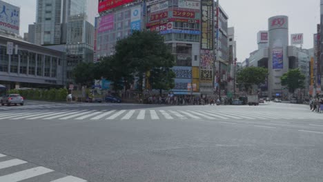 Die-Leere-Shibuya-Kreuzung-Mit-Vielen-Menschen,-Die-Auf-Einem-Bürgersteig-Gehen