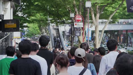 Handheld-slow-motion-shot-of-crowd-of-Japanese-pedestrians-walking-in-Tokyo-city