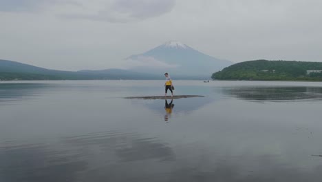 Slow-motion-of-young-male-walking-on-lake-sandbank-in-front-of-Mount-Fuji