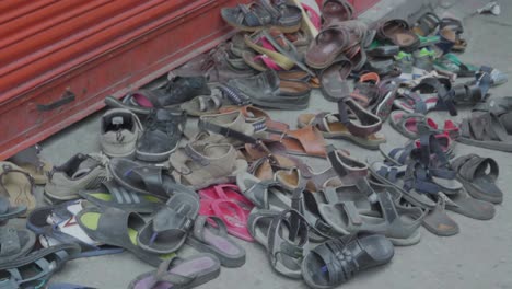 Viele-Alte-Sandalenschuhe-Liegen-In-Indien-Auf-Der-Straße