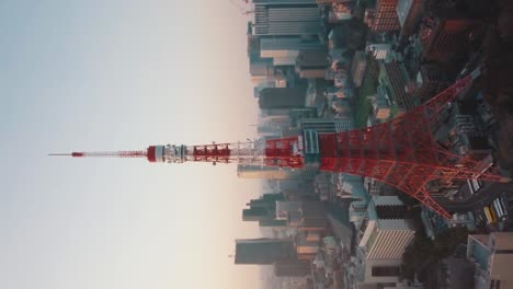Toma-Aérea-Vertical-De-La-Famosa-Torre-De-Tokio-Y-El-Hermoso-Horizonte-De-Tokio,-Japón-Durante-La-Puesta-De-Sol