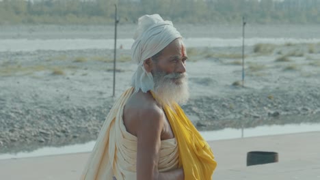 an-indian-hindu-guru-walking-along-the-streets-of-Rishikesh-wearing-a-yellow-dress